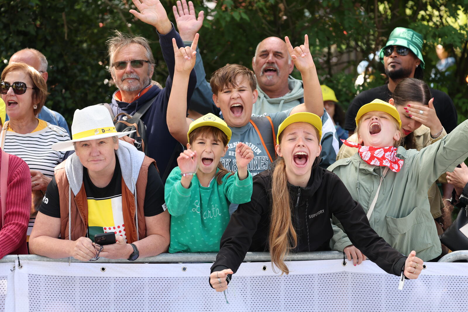 L'image montre des supporters du Tour de France derrière des barrières