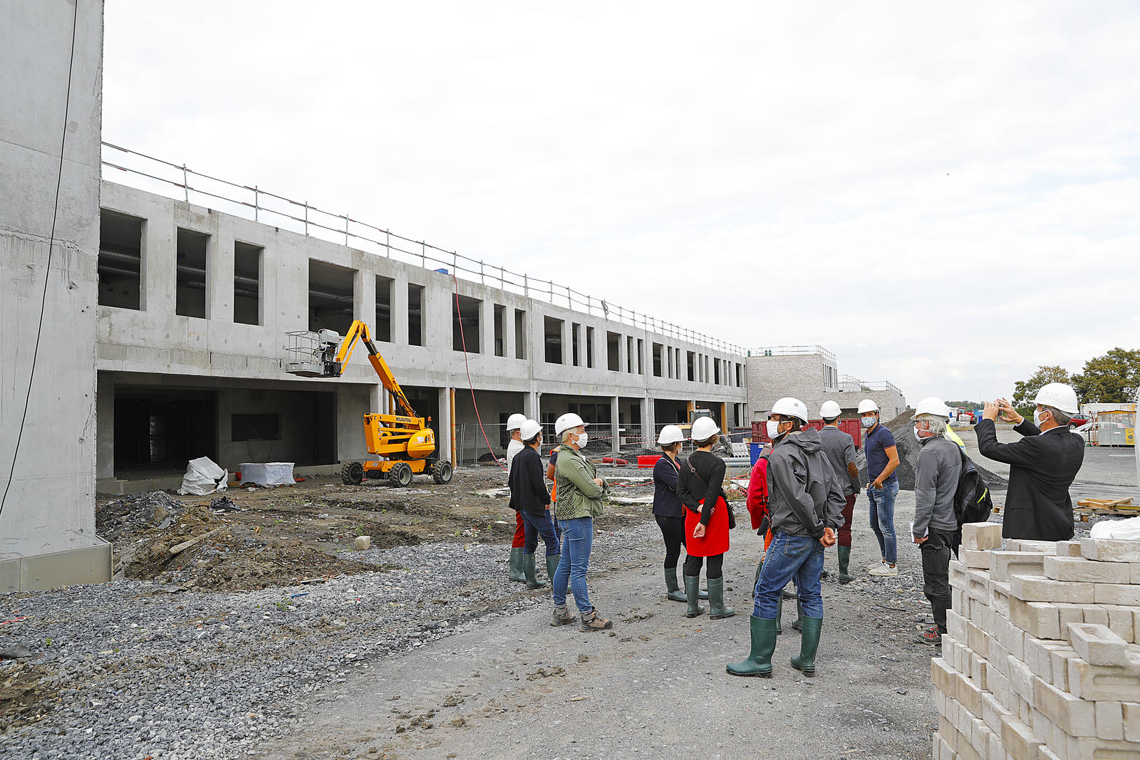 Un groupe de personnes devant un bâtiment en chantier